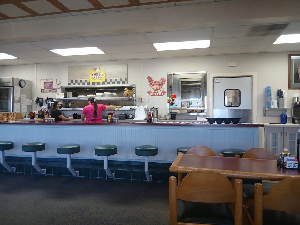 Counter seating beside a simple restaurant interior.